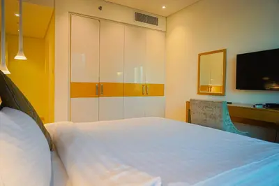 a bedroom with a large white bed with a television at Al Ashrafia Saray Magnificent 3BR Canal Views in Dubai