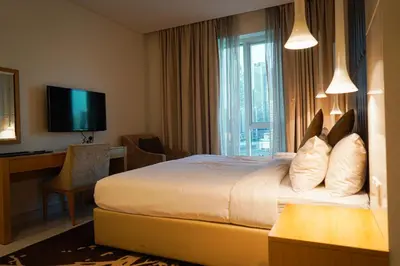 a hotel room with a bed and a desk and a television at Al Ashrafia Saray Magnificent 3BR Canal Views in Dubai