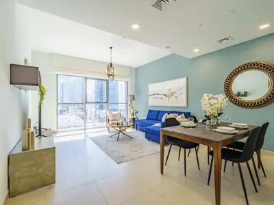 a living room with a table and a blue couch at Downtown Charming Condo Close to Dubai Mall in Dubai