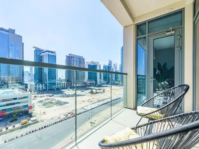 a balcony with two chairs and a view of a city at Downtown Charming Condo Close to Dubai Mall in Dubai