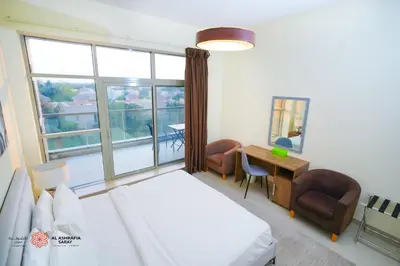a bedroom with a bed and a desk and a window at Alashrafia Saray, Lovely 2 BR apartment in Sport city in Dubai
