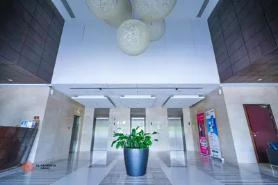 a potted plant in the middle of a lobby at Alashrafia Saray, Lovely 2 BR apartment in Sport city in Dubai
