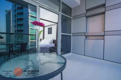 a glass table with a vase with a flower on it at Alasharafia Saray, Spacious 1BR apartment in Sport City in Dubai