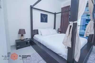 a bedroom with a bed and a window at Alasharafia Saray, Spacious 1BR apartment in Sport City in Dubai
