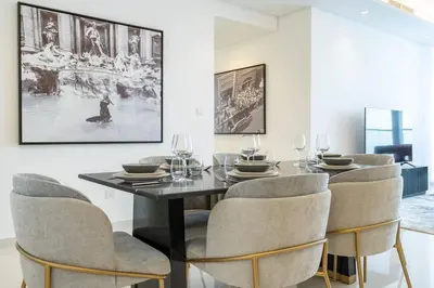 a dining room with a black table and chairs at La Dolce Vita Residence by Suiteable Interiors in Dubai