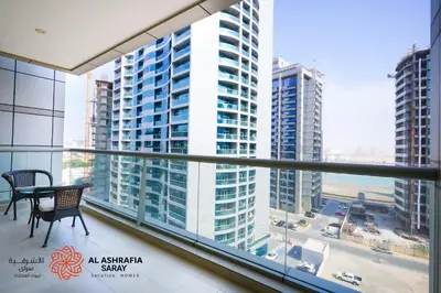 a balcony with a table and a view of buildings at Alashrafia Saray, Charming 1BR apartment in Sport City in Dubai