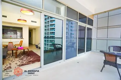 an open living room with a view of a city at Alashrafia Saray, Charming 1BR apartment in Sport City in Dubai