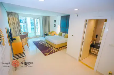 a bedroom with a bed and a desk in a room at Al Ashrafia Saray - Extraordinary Studio in Canal View in Dubai