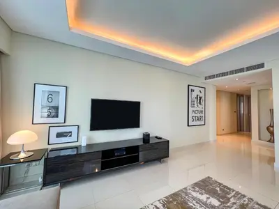 a living room with a flat screen tv on a wall at Luton Vacation Homes - Damac Paramount 2BR High Floor, Business Bay, Dubai 61AB06 in Dubai