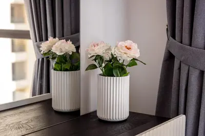 two white vases with pink flowers on a window sill at Luxury 1 bedroom with amazing full sea view! in Dubai