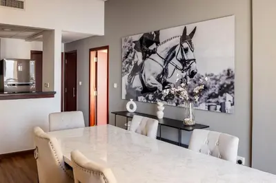 a dining room with a large picture of a horse on the wall at Luxury 1 bedroom with amazing full sea view! in Dubai
