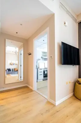 a living room with a flat screen tv on a wall at Exclusive Designer Studio by Marina, Beach & Mall in Dubai