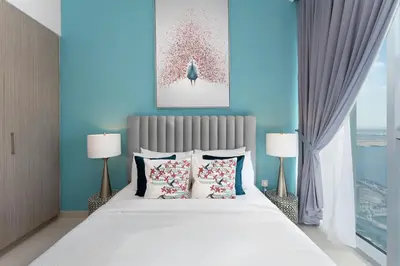 a bedroom with a large white bed with two lamps at Maison Privee - Trendy Apt on the Creek w/ Superb Dubai Skyline Vw in Dubai