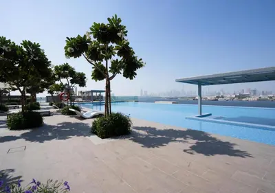 a swimming pool with trees and a view of the city at Maison Privee - Trendy Apt on the Creek w/ Superb Dubai Skyline Vw in Dubai