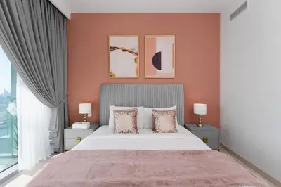 a bedroom with a large bed with pink walls at Maison Privee - Trendy Apt on the Creek w/ Superb Dubai Skyline Vw in Dubai