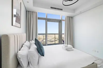 a bedroom with a white bed and a large window at StoneTree - Paramount Tower Hotel&Residences 3 BR - Sea View and Infinity Pool in Dubai