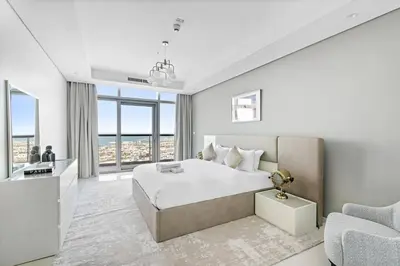 a white bedroom with a large bed and a couch at StoneTree - Paramount Tower Hotel&Residences 3 BR - Sea View and Infinity Pool in Dubai