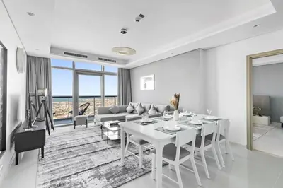 a white living room with a table and a couch at StoneTree - Paramount Tower Hotel&Residences 3 BR - Sea View and Infinity Pool in Dubai