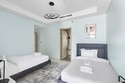 two beds in a room with white walls at StoneTree - Paramount Tower Hotel&Residences 3 BR - Sea View and Infinity Pool in Dubai