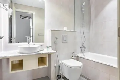 a bathroom with a toilet and a sink and a shower at StoneTree - Paramount Tower Hotel&Residences 3 BR - Sea View and Infinity Pool in Dubai