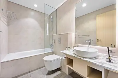 a bathroom with a sink and a toilet and a tub at StoneTree - Paramount Tower Hotel & Residences 2 BR - Infinity Pool & Stunning View in Dubai