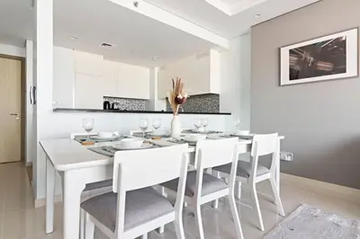 a white dining room with a white table and chairs at StoneTree - Paramount Tower Hotel&Residences 2 BR - Amazing View in Dubai