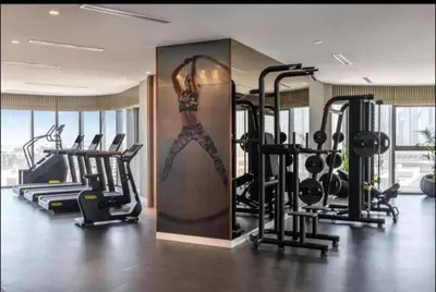 a gym with a woman painted on the wall at StoneTree - Paramount Tower Hotel&Residences 2 BR - Amazing View in Dubai