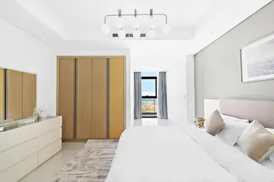 a white bedroom with a large bed and a bathroom at StoneTree - Paramount Tower Hotel&Residences 2 BR - Amazing View in Dubai