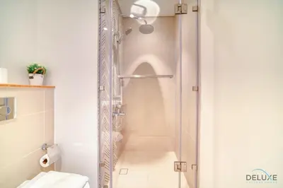 a shower with a glass door in a bathroom at Jovial 1BR at Collective Tower 2 Mohammed Bin Rashid City by Deluxe Holiday Homes in Dubai