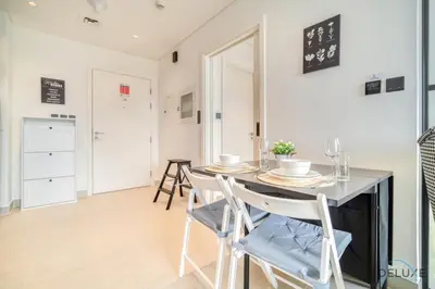 a kitchen and dining room with a table and chairs at Jovial 1BR at Collective Tower 2 Mohammed Bin Rashid City by Deluxe Holiday Homes in Dubai