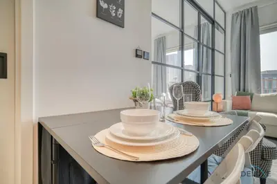 a table with plates and dishes on it in a living room at Jovial 1BR at Collective Tower 2 Mohammed Bin Rashid City by Deluxe Holiday Homes in Dubai