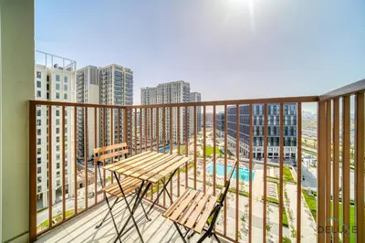 a balcony with two chairs and a table on it at Jovial 1BR at Collective Tower 2 Mohammed Bin Rashid City by Deluxe Holiday Homes in Dubai