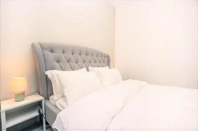 a bedroom with a white bed and a side table at Royal Casa- Marina Diamond 2 in Dubai
