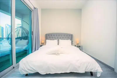 a bedroom with a white bed with a large window at Royal Casa- Marina Diamond 2 in Dubai