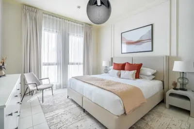 a white bedroom with a large bed and a desk at GuestReady - Sweet Sunshine in Downtown in Dubai