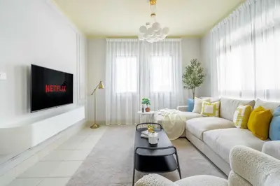 a living room with a white couch and a tv at GuestReady - Sweet Sunshine in Downtown in Dubai