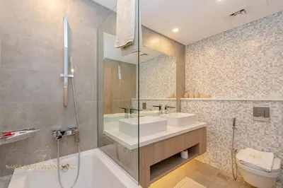 a bathroom with two sinks and a tub and a toilet at Marco Polo - Wake up to stunning sea views at Stella Maris in Dubai
