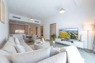 a living room with a white couch and a tv at Marco Polo - Wake up to stunning sea views at Stella Maris in Dubai