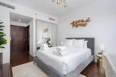 a bedroom with a large white bed with white sheets at Stylish and Central 1 BD in Downtown Dubai in Dubai