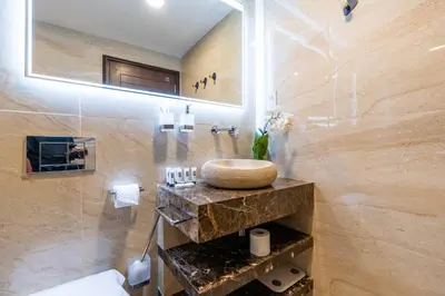 a bathroom with a sink and a marble wall at Stylish and Central 1 BD in Downtown Dubai in Dubai