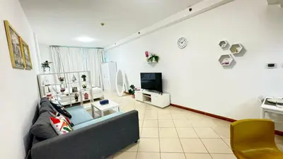 a living room with a couch and a tv at Spacious studio apartment in Dubai Marina close to metro and beach in Dubai