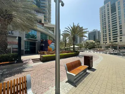 a park with two benches and a street light at Spacious studio apartment in Dubai Marina close to metro and beach in Dubai