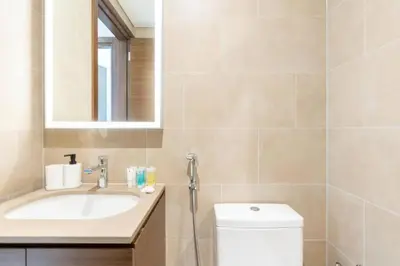a bathroom with a sink and a toilet and a mirror at Cozy 1bdr 10' from Burj Khalifa in Dubai