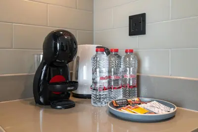 a kitchen counter with bottles of water and a blender at Cozy 1bdr 10' from Burj Khalifa in Dubai