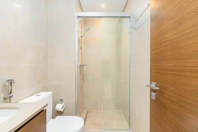 a bathroom with a shower with a toilet and a sink at Cozy 1bdr 10' from Burj Khalifa in Dubai
