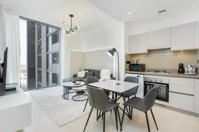 a kitchen and dining room with a table and chairs at Cozy 1bdr 10' from Burj Khalifa in Dubai