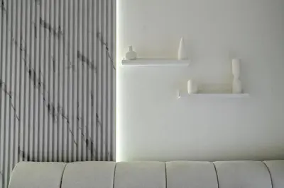 a living room with a white couch and a wall at Cozy 1bdr 10' from Burj Khalifa in Dubai