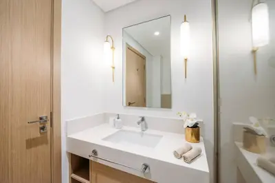 a white bathroom with a sink and a mirror at Modern & Chic 2bedroom with Balcony Dubai Creek in Dubai