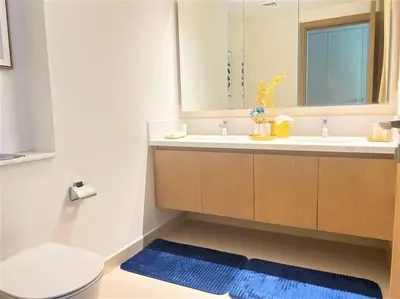 a bathroom with a sink and a toilet and a mirror at Modern & Chic Waterfront 2bed balcony Dubai Creek in Dubai