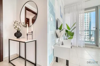 a mirror on a wall in a room with a table at Glamorous 1BR at Residences 5 Downtown Dubai by Deluxe Holiday Homes in Dubai
